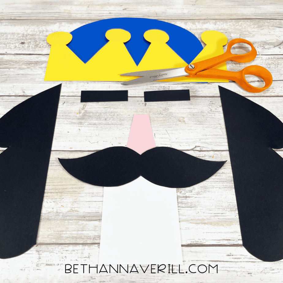 Cut out nutcracker pieces including crown, mustache, hat, nose, and hair.