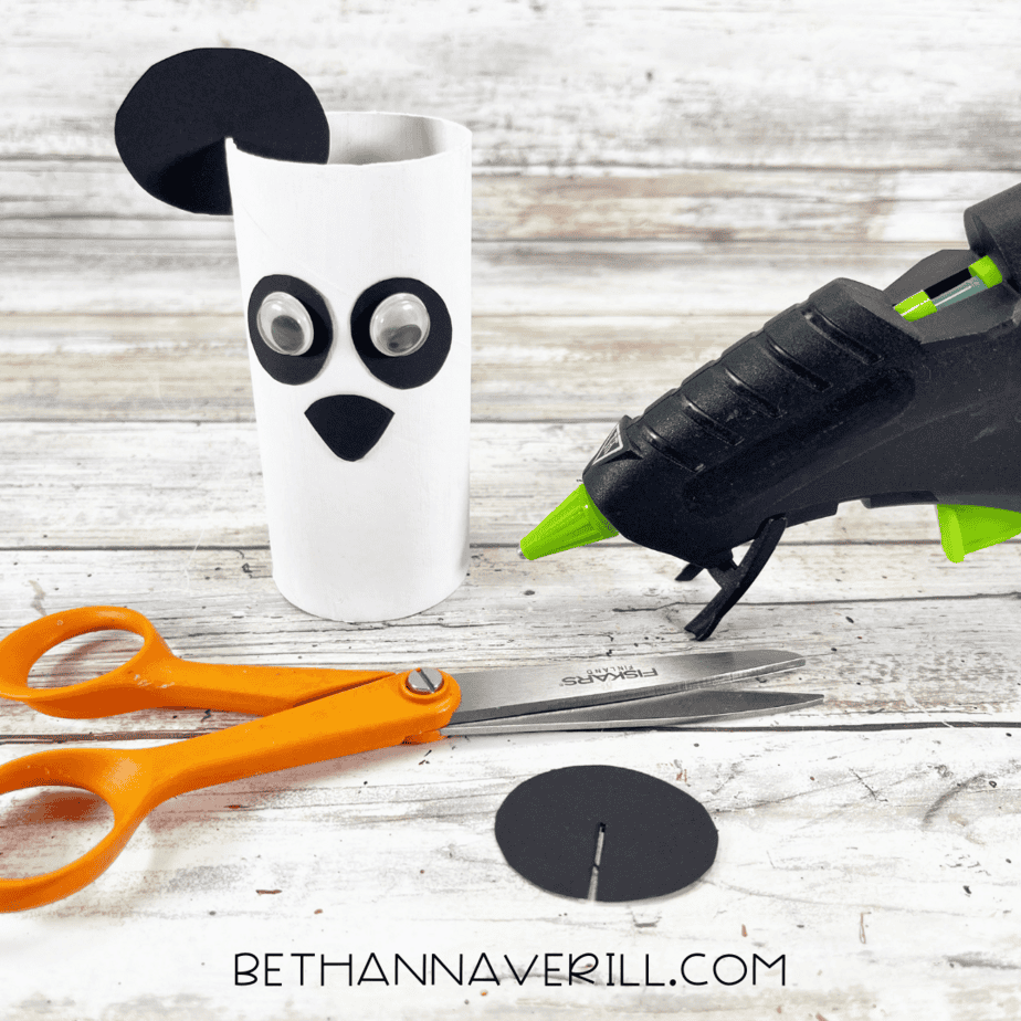 Panda craft with ears being attached to the top of the paper roll.