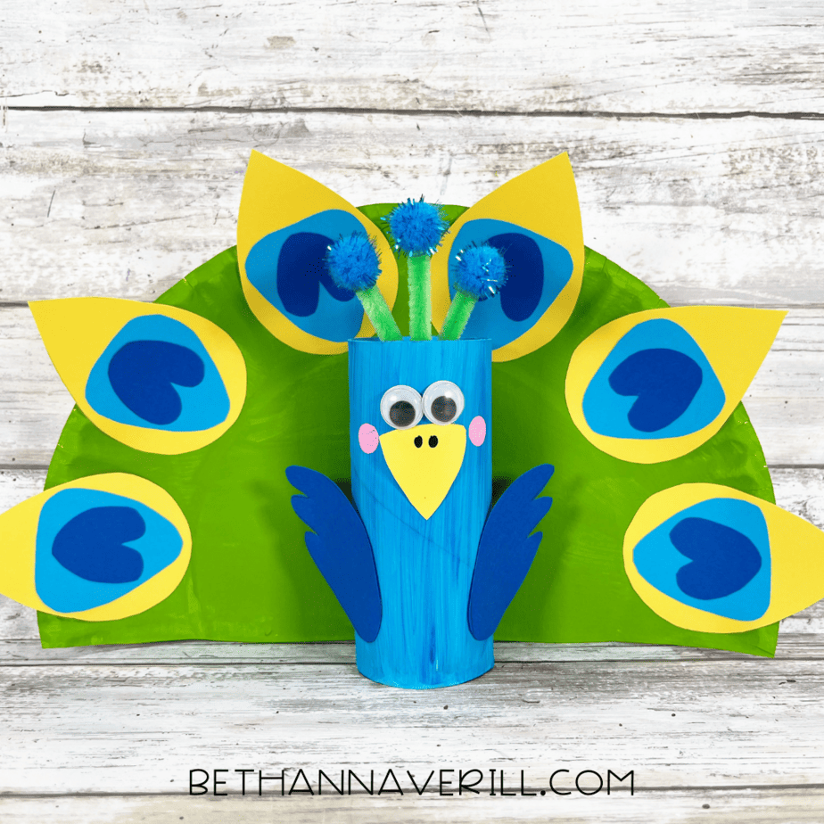 Finished peacock paper roll craft with colorful tail feathers and decorated body.