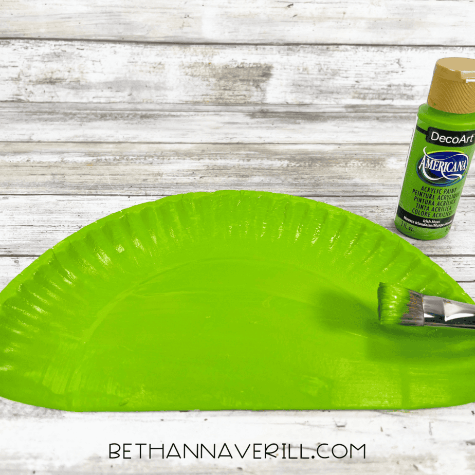 Paper plate painted green with acrylic paint for peacock feathers.