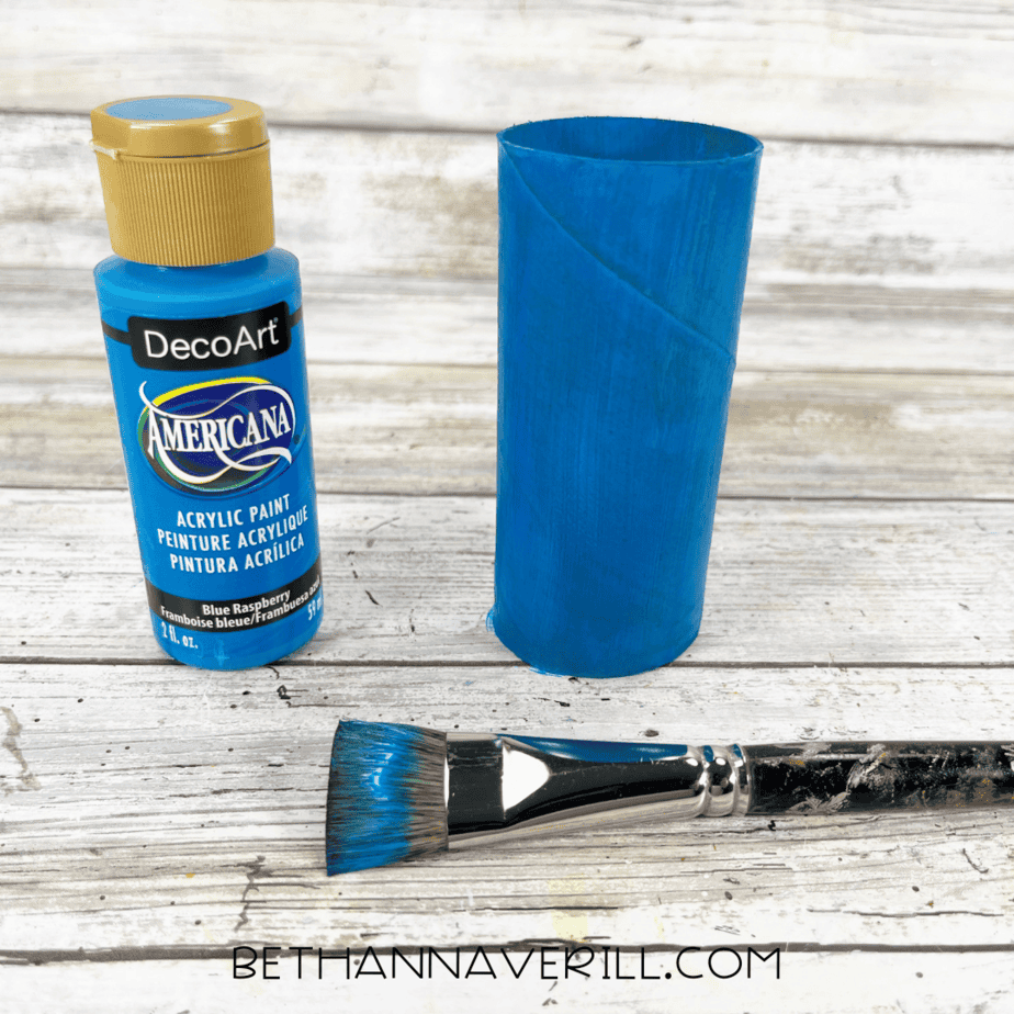 Toilet paper roll painted blue for peacock’s body.