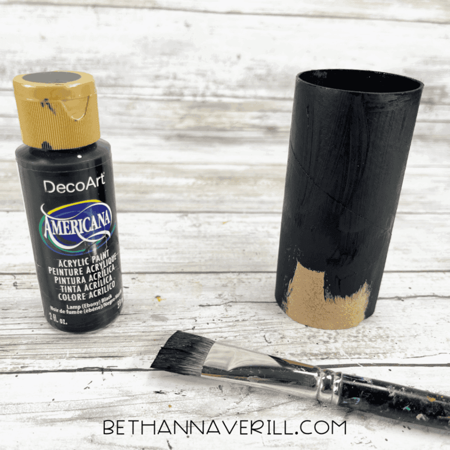 Toilet paper roll being painted black with acrylic paint.