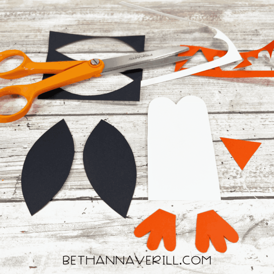 Penguin parts cut out: wings, belly, beak, and feet.