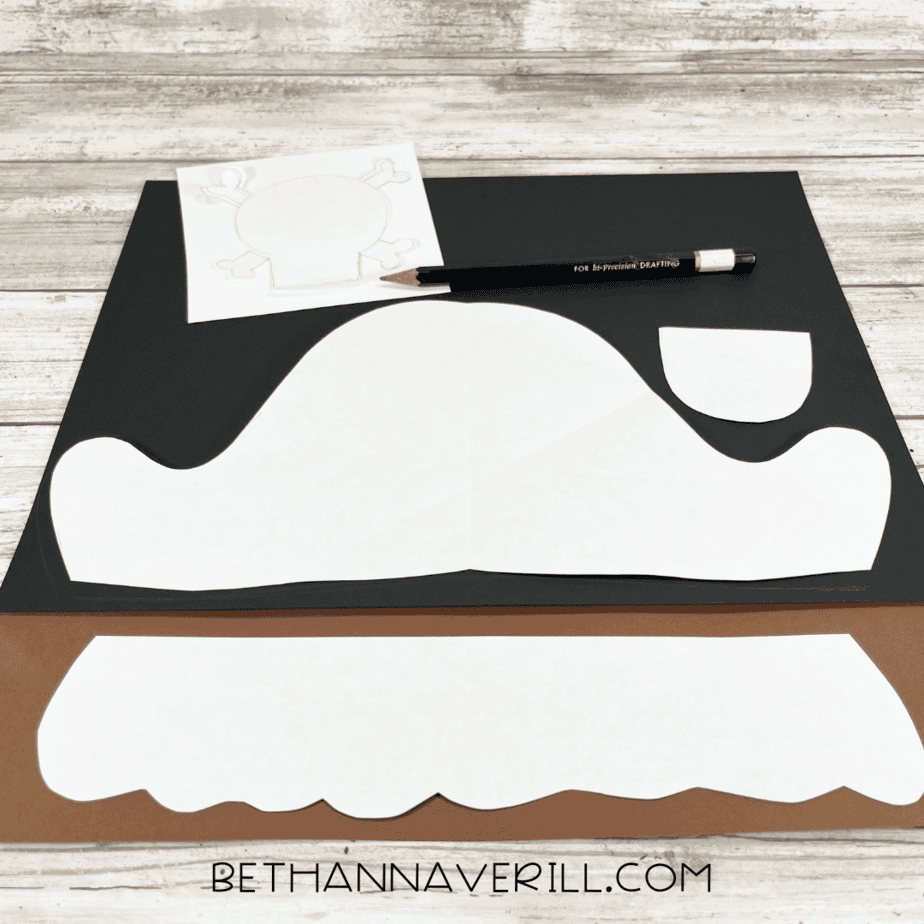 Pirate craft templates traced onto black, brown, and white construction paper with a pencil.
