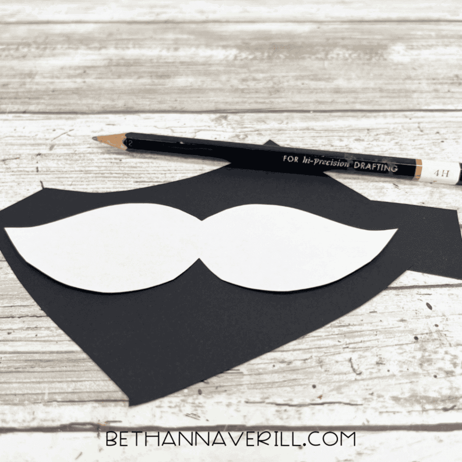 Mustache shape traced onto black paper.