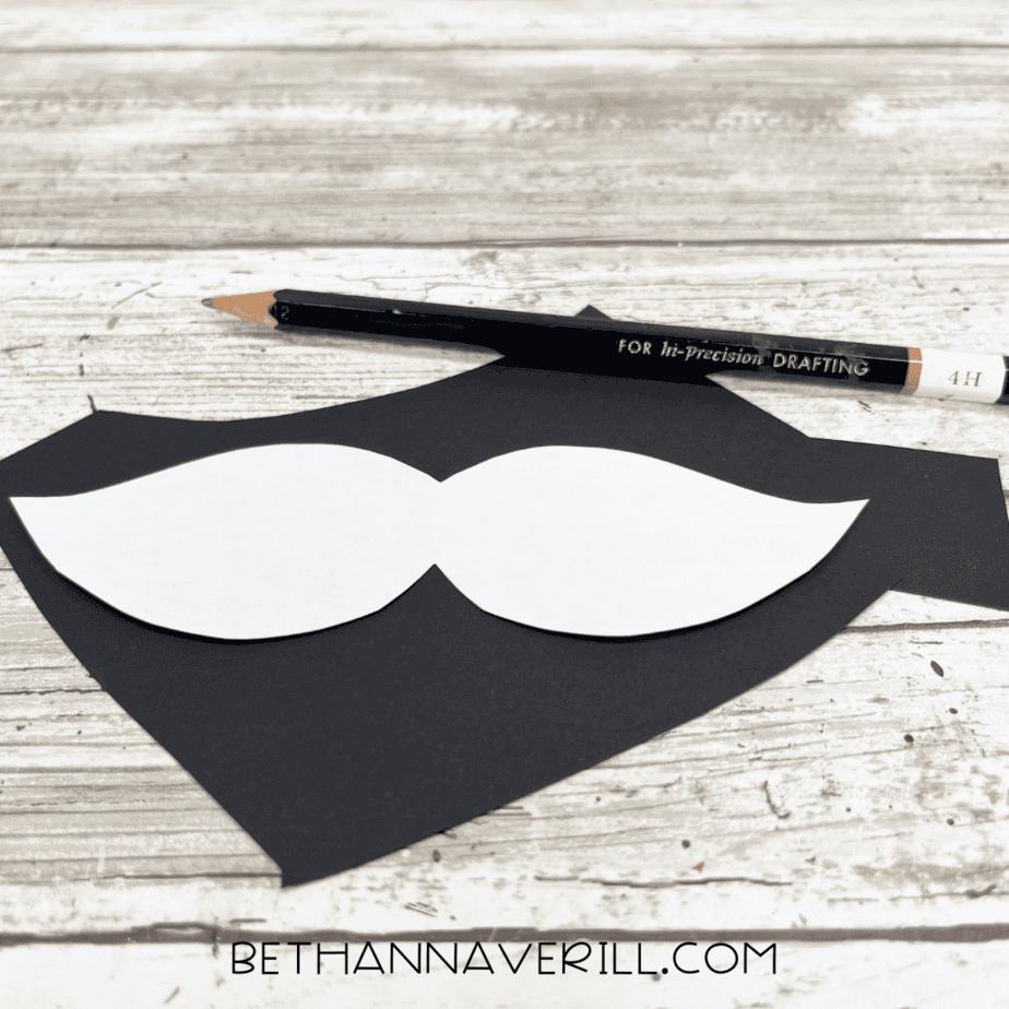 Mustache shape traced onto black paper.