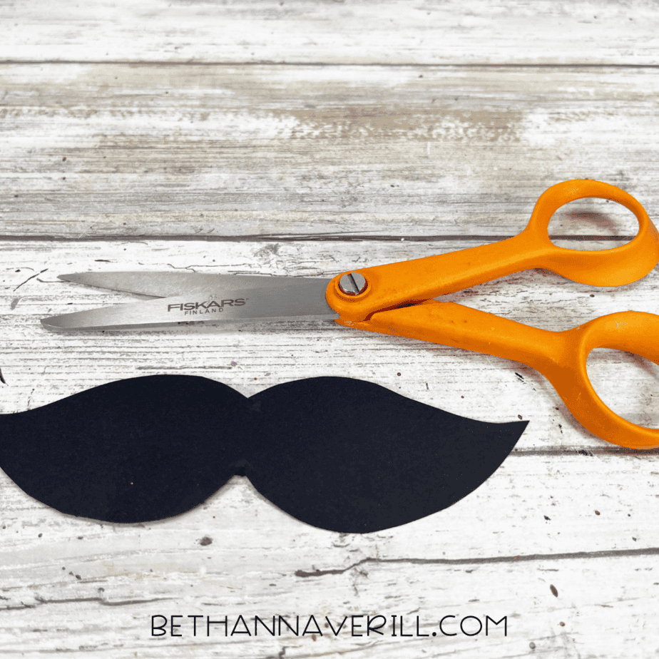 Black paper mustache cut out with scissors.