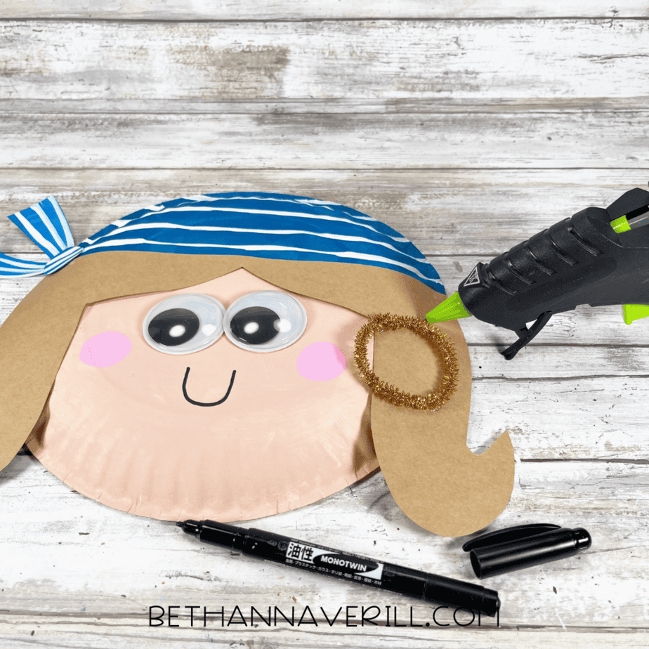 Gold earring glued to pirate first mate girl craft.