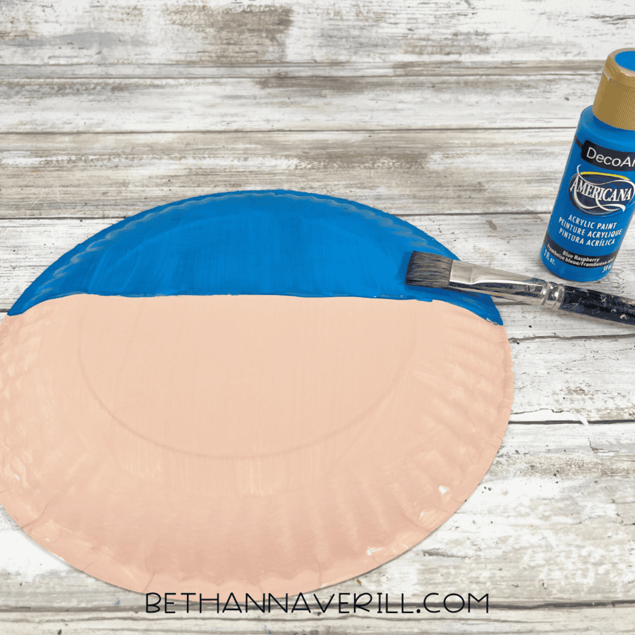 Paper plate with blue paint at the top for bandana.