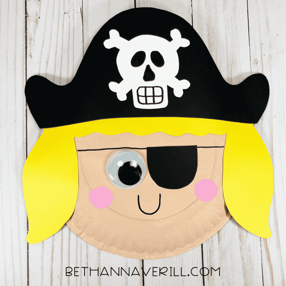 Completed Pirate Girl Paper Plate Craft with hat, yellow hair, eye patch, and rosy cheeks.