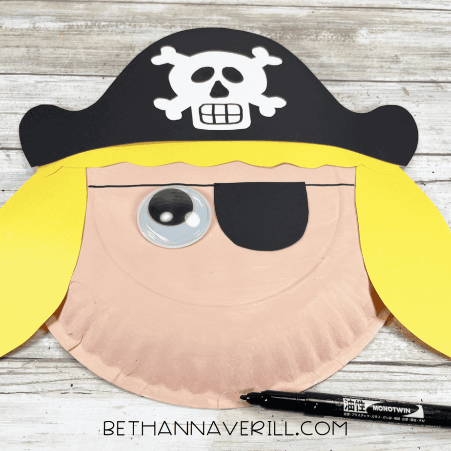 Paper plate pirate girl with hat, hair, and eye patch added.