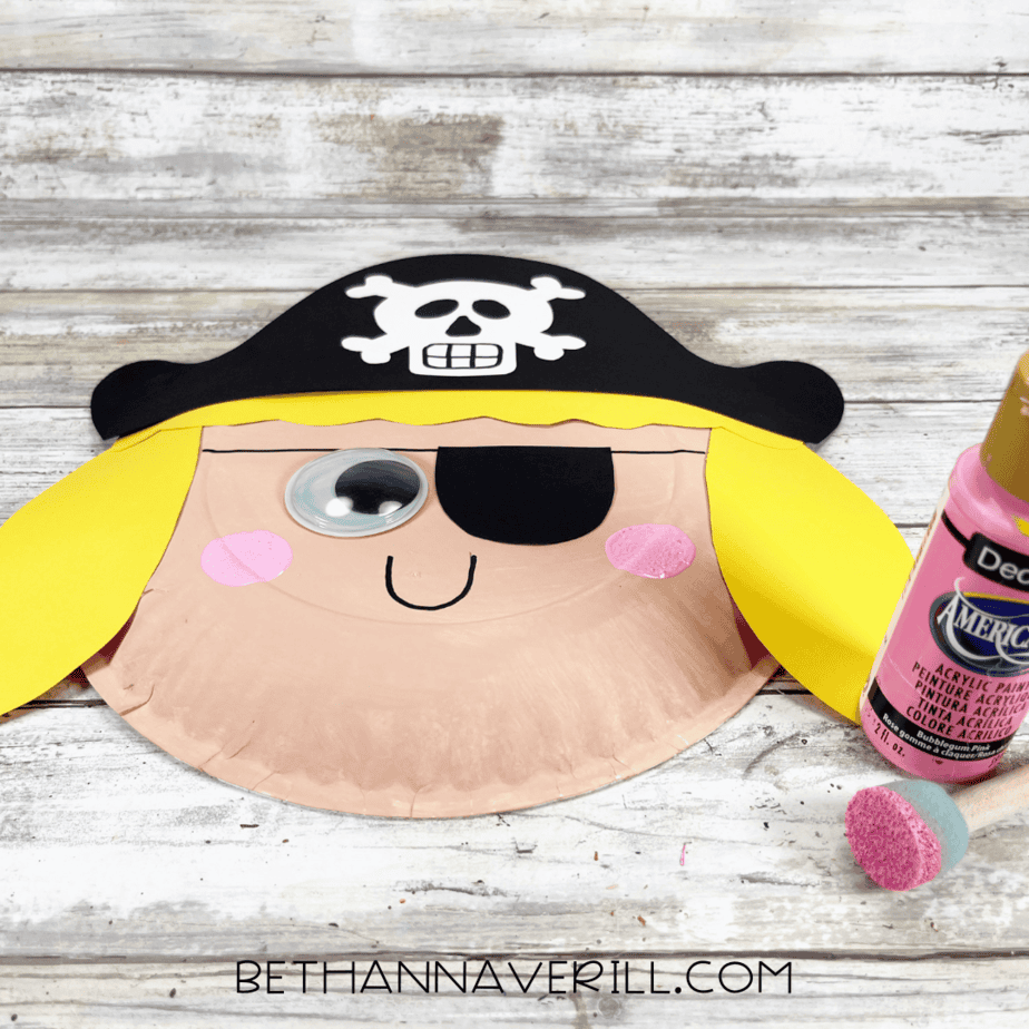 Pirate girl craft with painted pink cheeks and smile drawn on face.