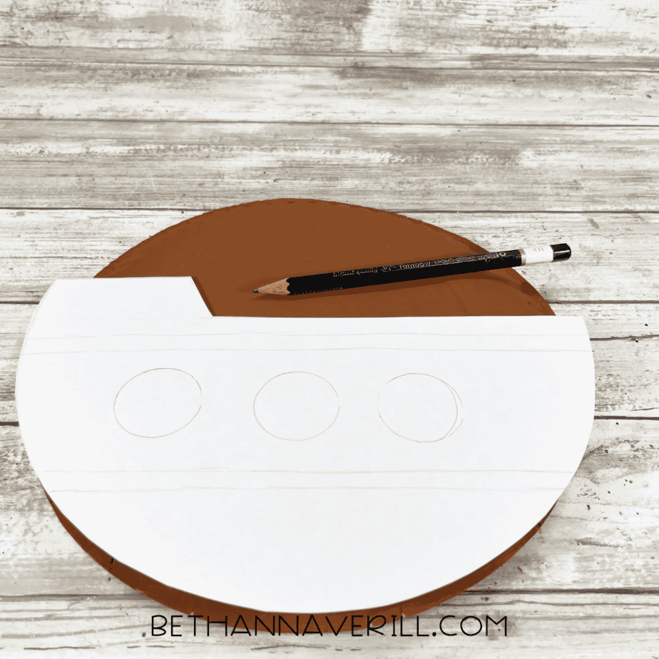 Template traced on paper plate to shape the pirate ship body.