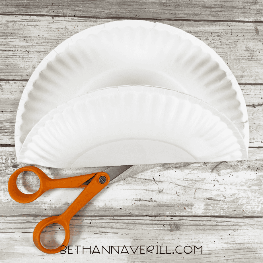Paper plate cut in half with scissors for the rainbow base.
