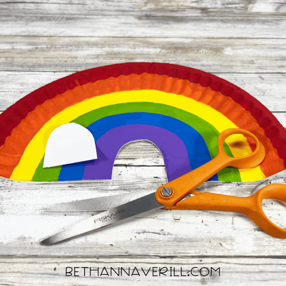 Rainbow paper plate with arch cut out using scissors.