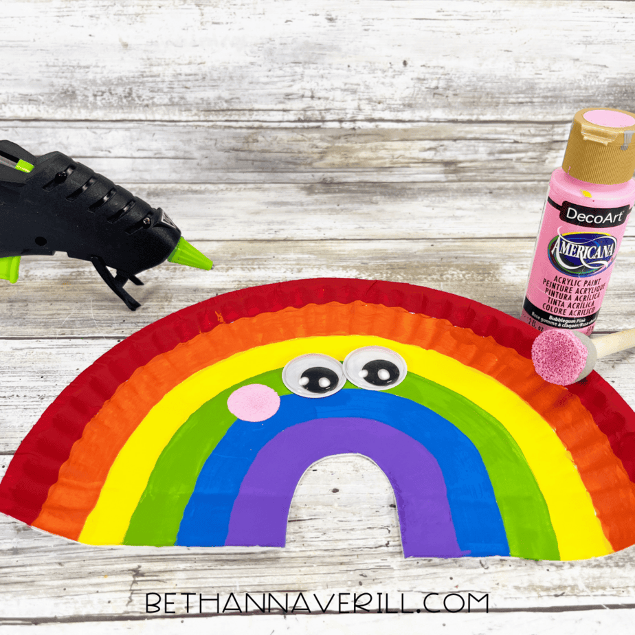 Rainbow paper plate with pink cheeks added using a sponge dauber.
