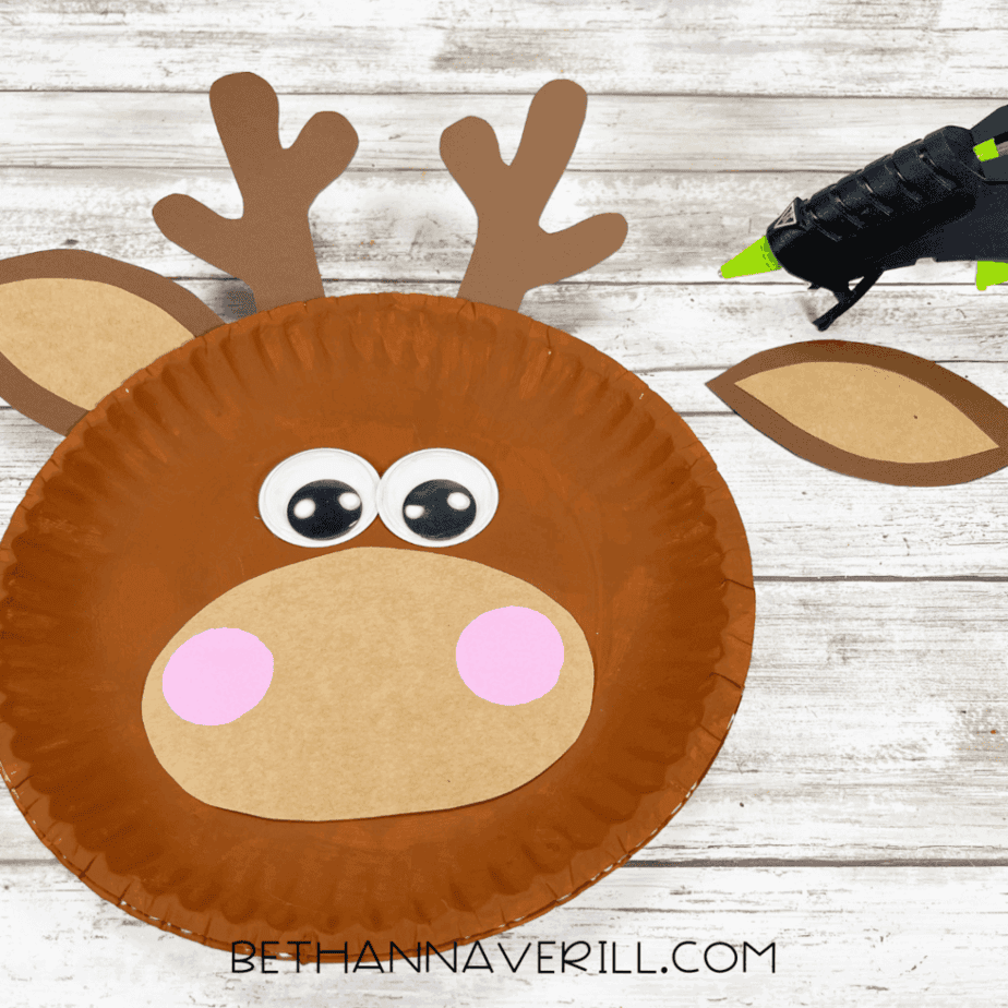 Paper plate with antlers and ears glued in place on top.
