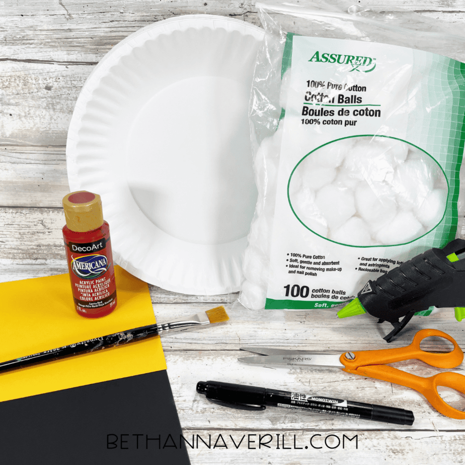 Materials for Santa Belt Paper Plate Craft including paint, cotton balls, and paper.