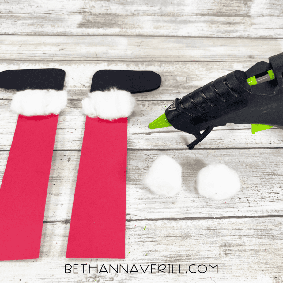 Black paper boots with cotton ball trim glued at the top.