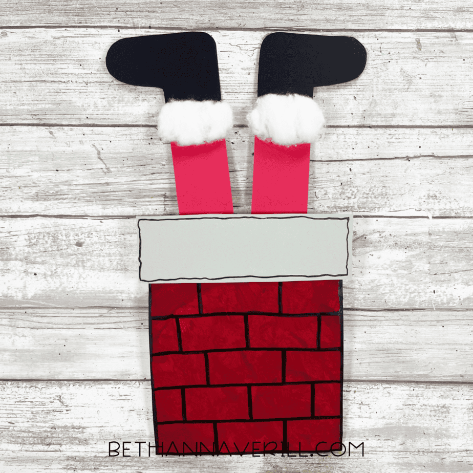 Finished Santa Chimney paper plate craft with Santa’s legs in chimney.