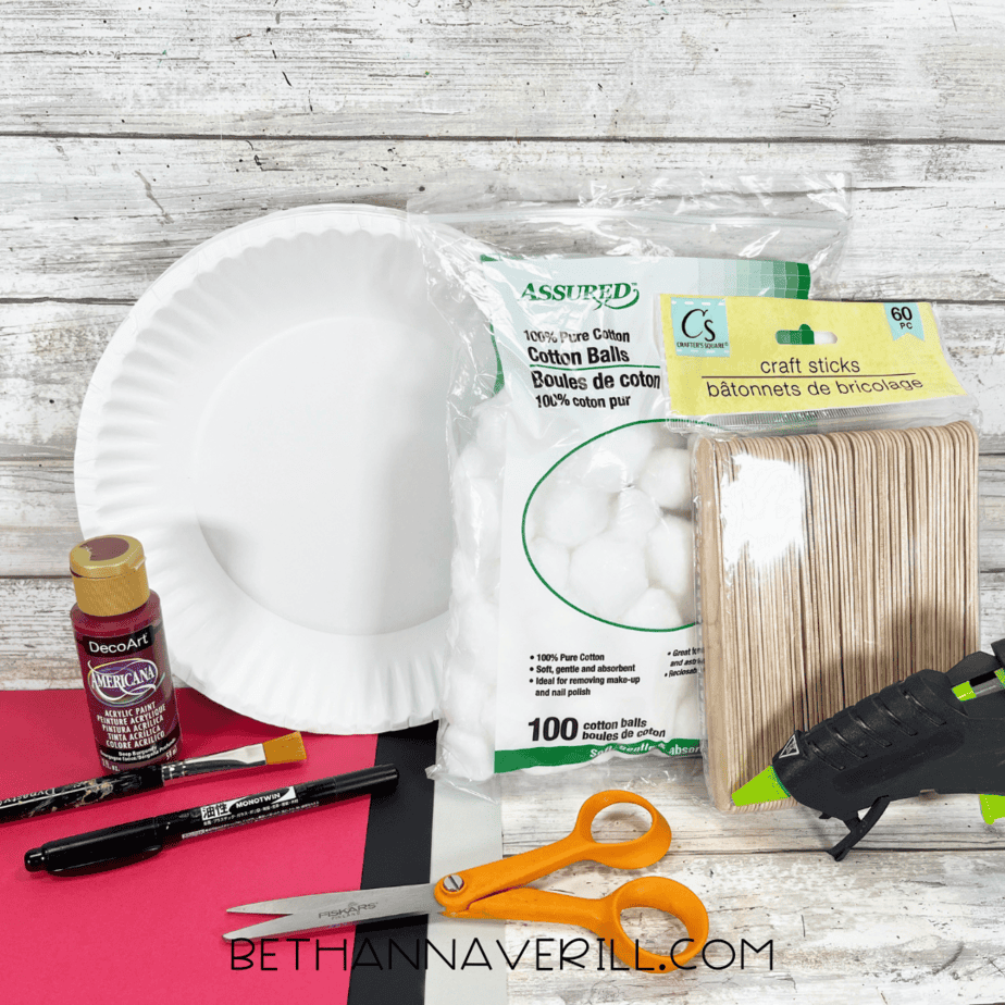 Materials for Santa Chimney paper plate craft including paint, cotton balls, craft sticks, and paper.