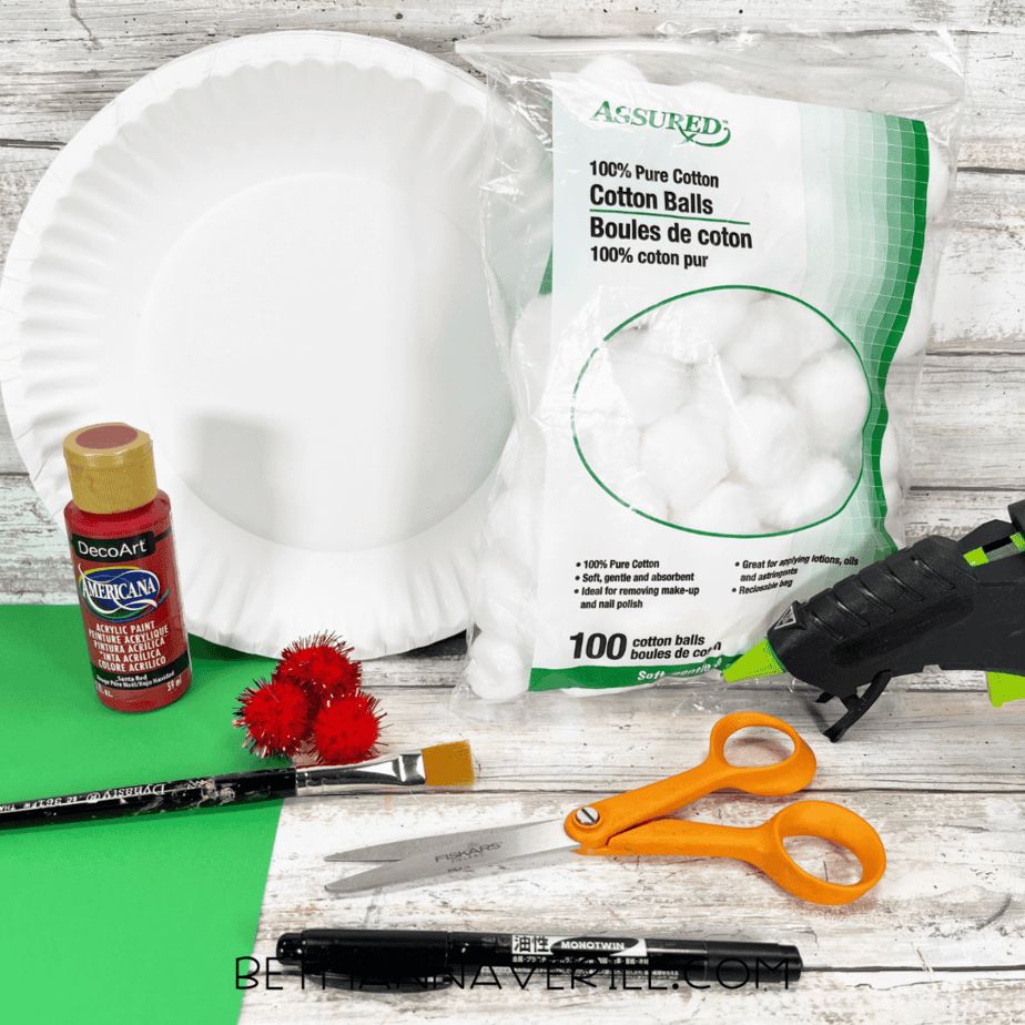 Craft materials including paper plate, red paint, cotton balls, pom-poms, and construction paper.