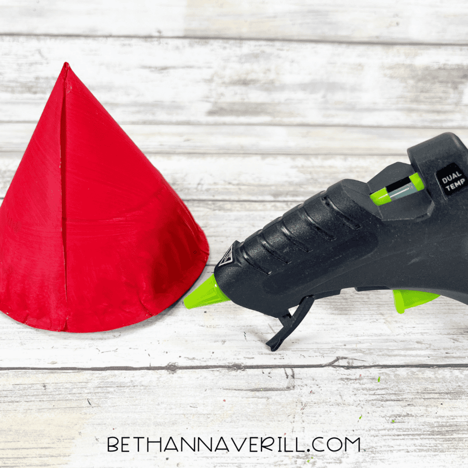 Red paper plate rolled into a cone shape and glued to form a hat.