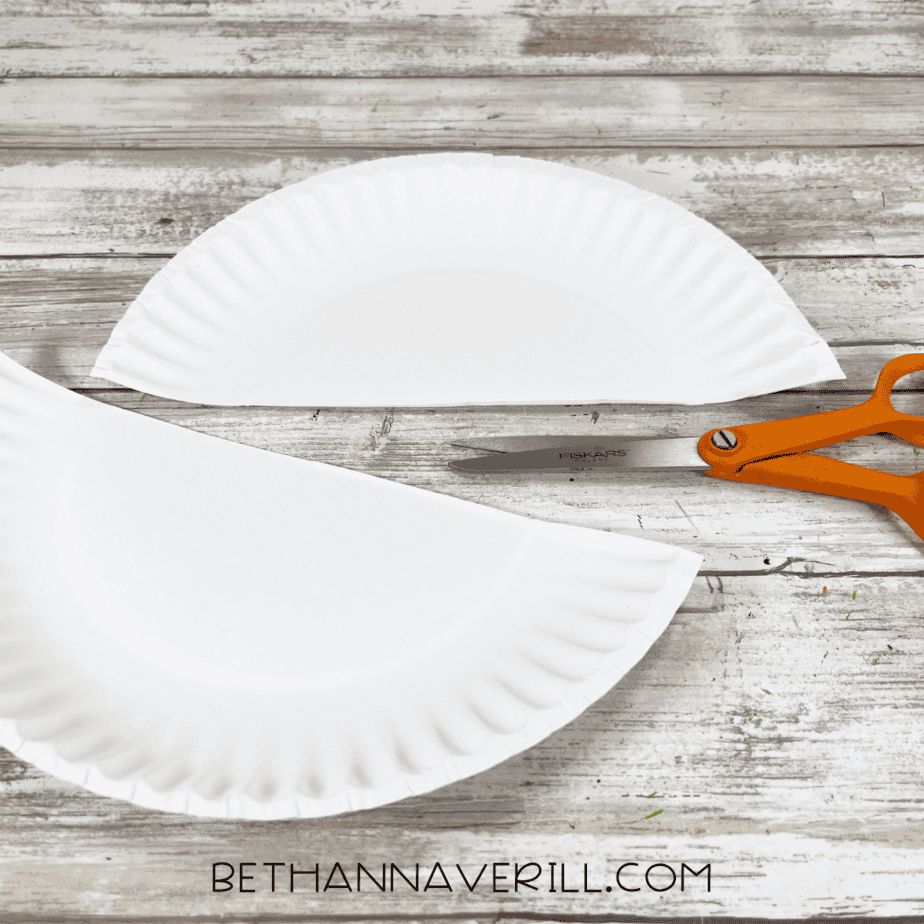Paper plate cut in half with scissors for the Santa craft base.