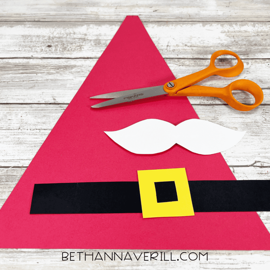 Red triangle, yellow buckle, black strip, and white mustache cut out from construction paper.