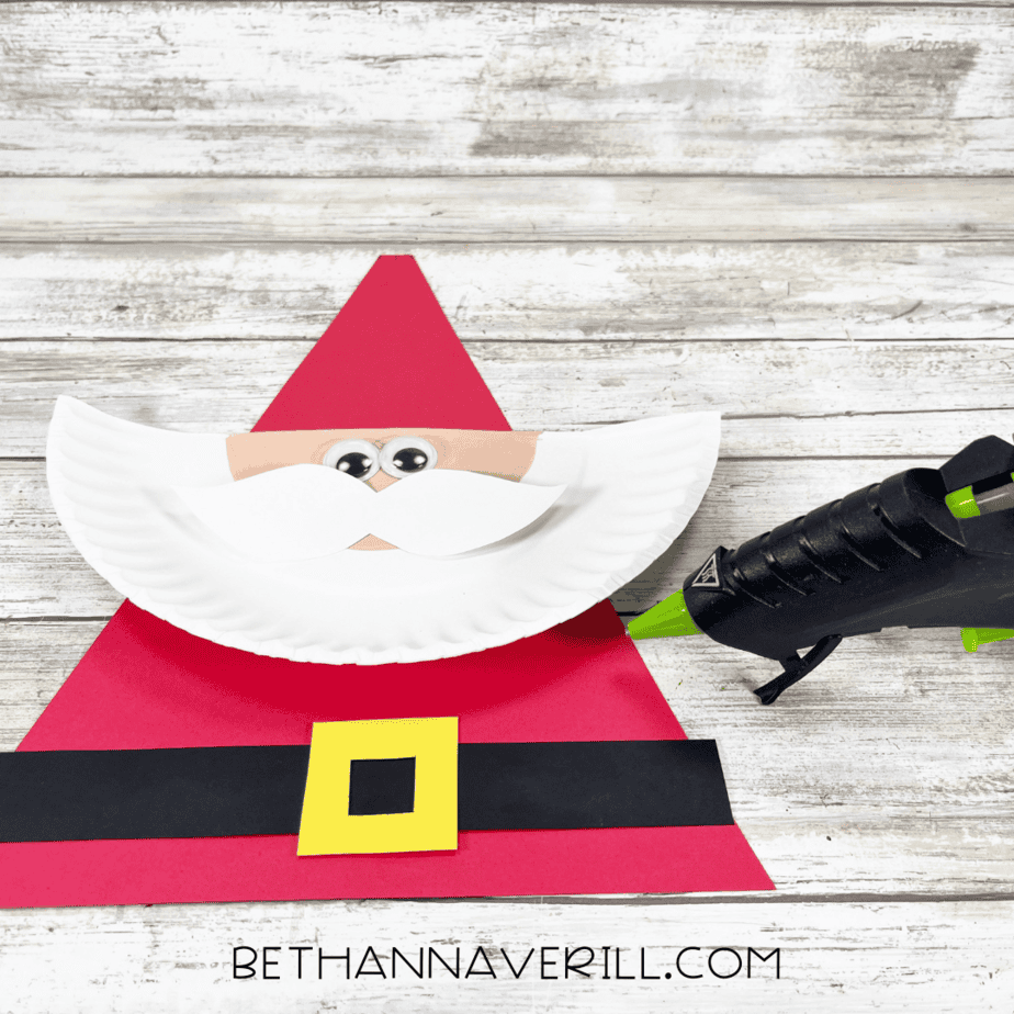 Santa craft with red triangle hat attached to paper plate face.