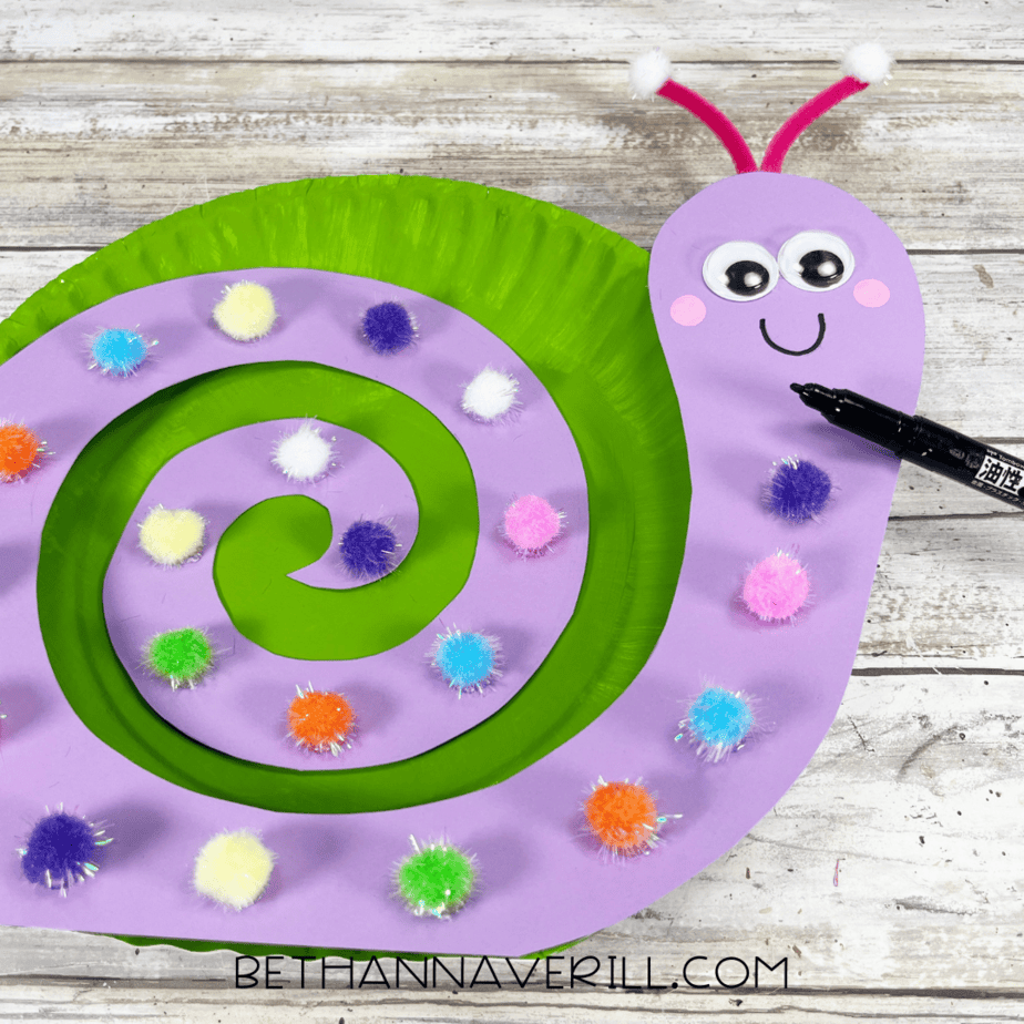 Paper plate snail with finished details being outlined with a black marker.