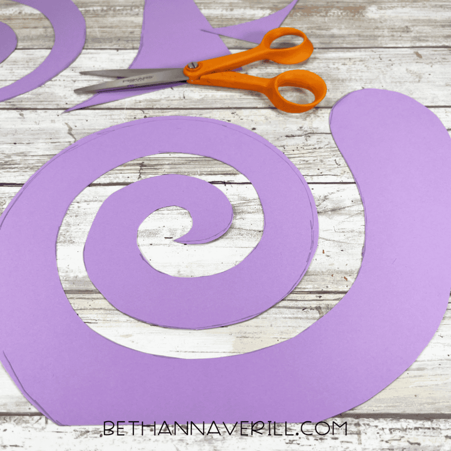 Snail shell spiral cut out of purple construction paper.