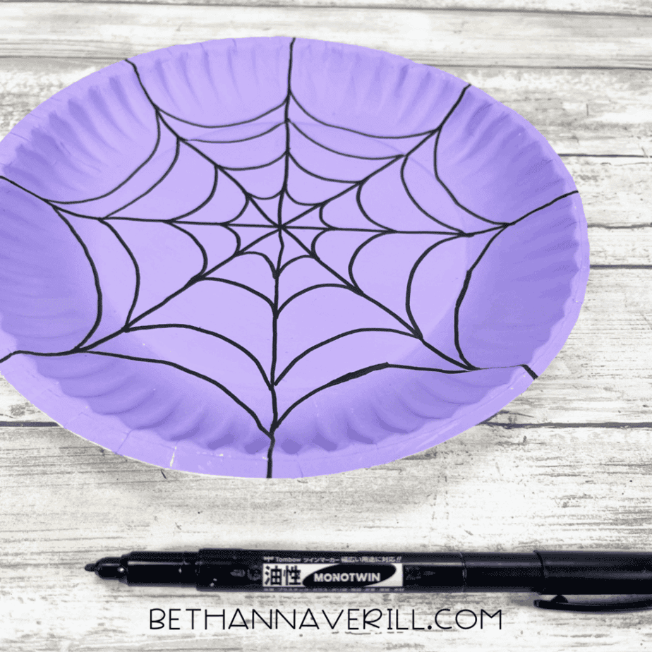 Purple plate with completed black spiderweb pattern.