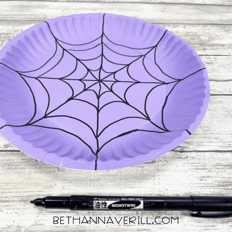 Purple plate with completed black spiderweb pattern.