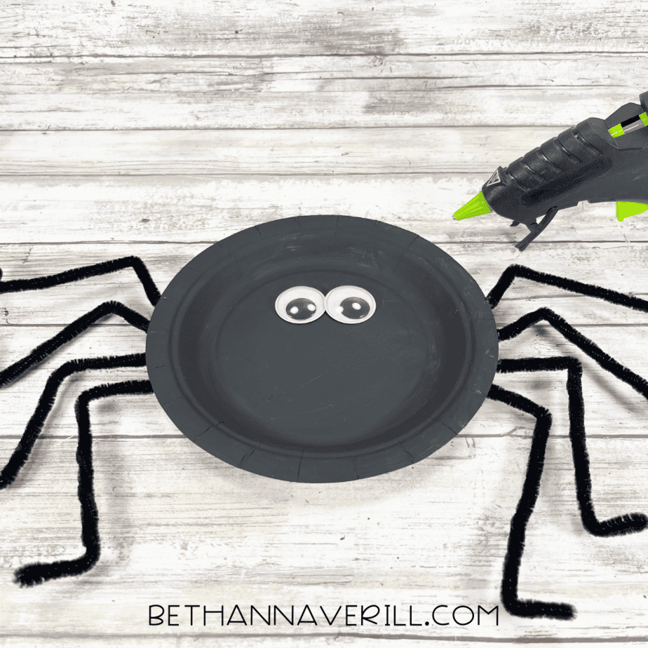 Googly eyes glued onto the black spider plate.
