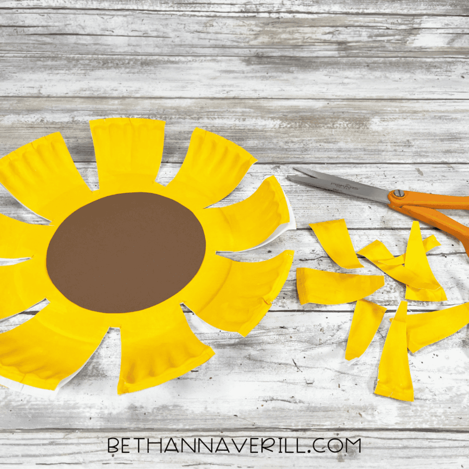 Paper plate cut into petal shapes to resemble a sunflower.