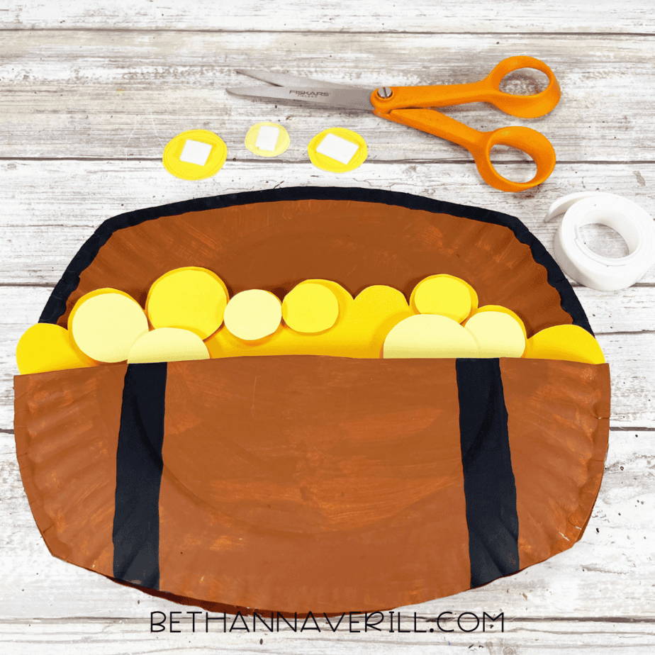 Treasure chest decorated with yellow coins layered inside.