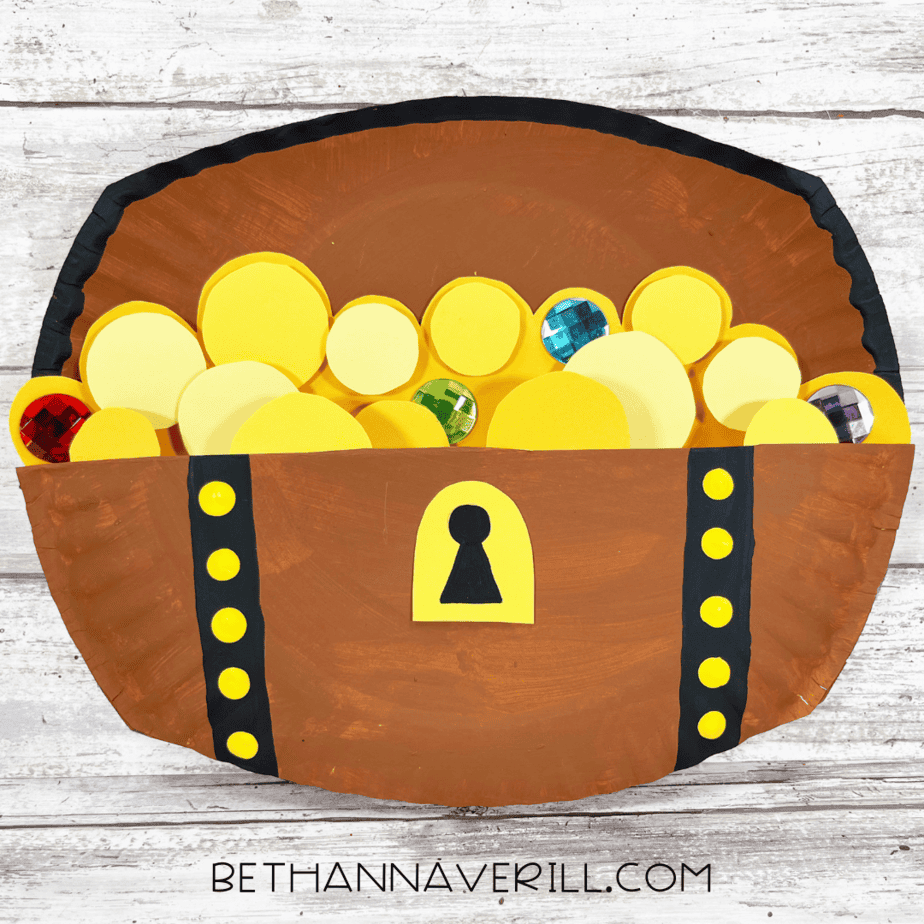 Completed treasure chest craft with gold coins and colorful gems.