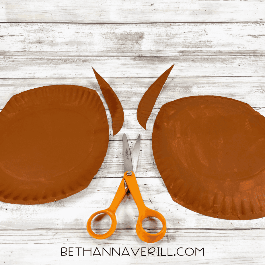 Brown paper plates cut into rounded chest shapes with scissors.