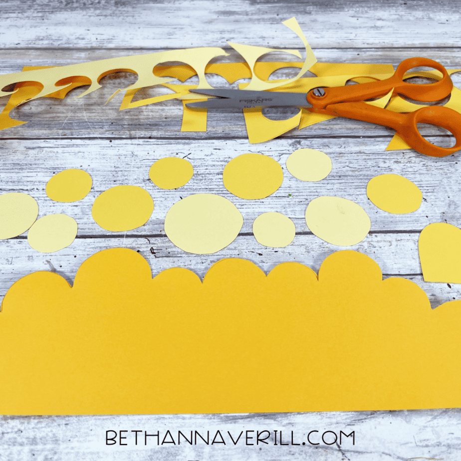 Yellow construction paper cut into circles and wavy treasure strips.