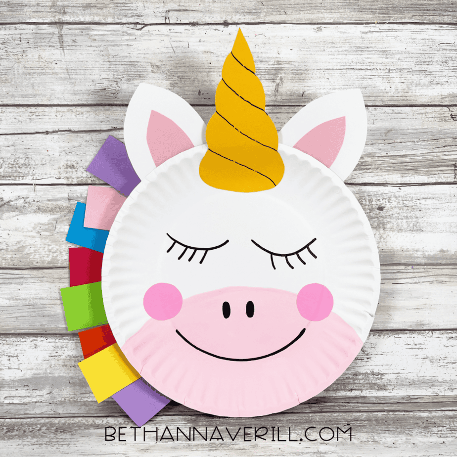 Completed unicorn paper plate craft with rainbow mane, pink snout, and horn.