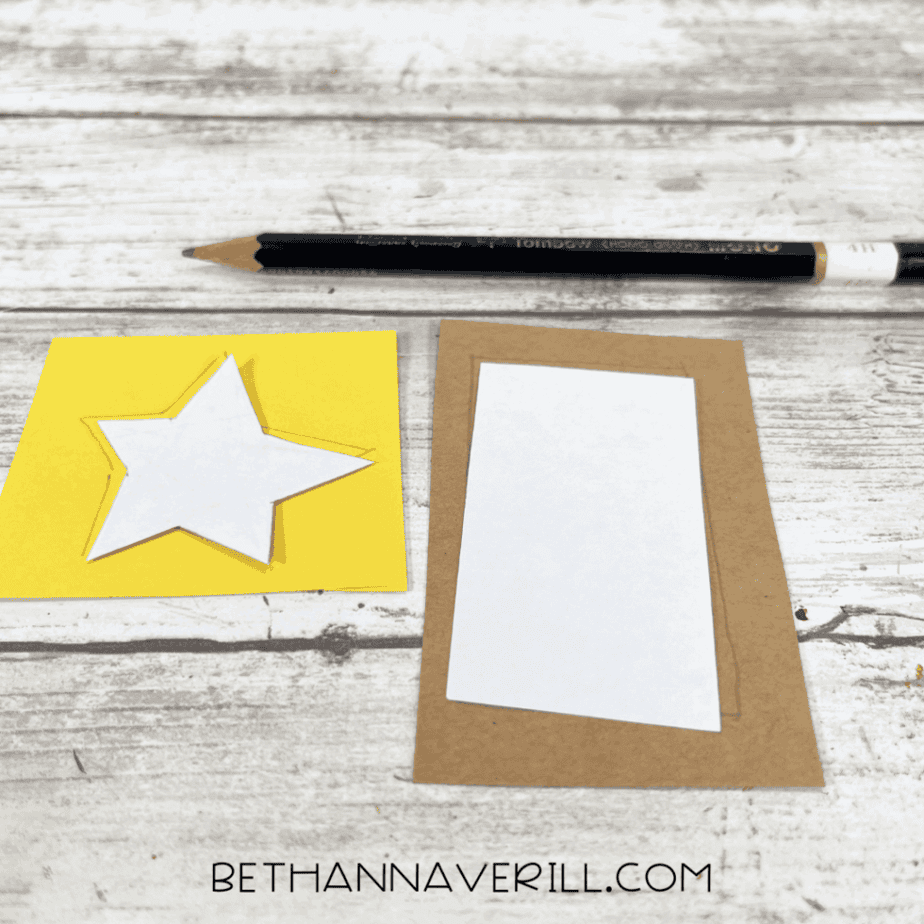 Yellow star and brown rectangle templates traced onto paper for tree decorations.