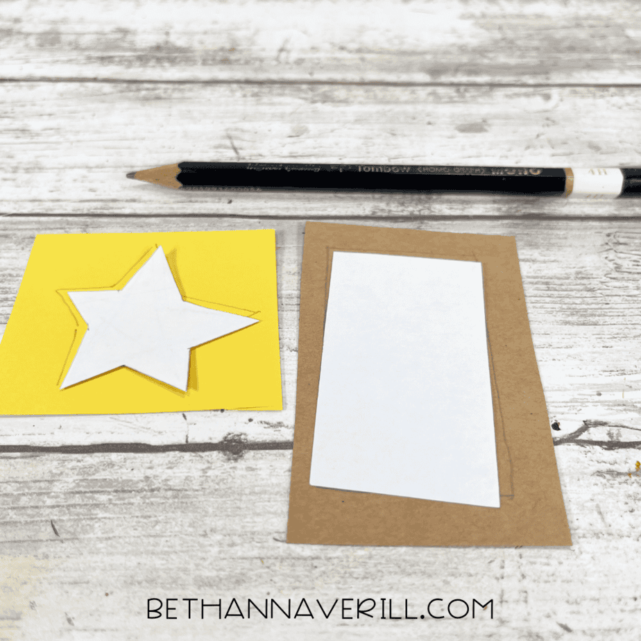 Yellow star and brown rectangle templates traced onto paper for tree decorations.
