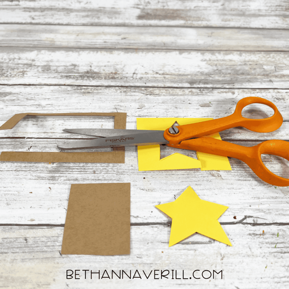 Cut out yellow star and brown trunk pieces beside scissors.