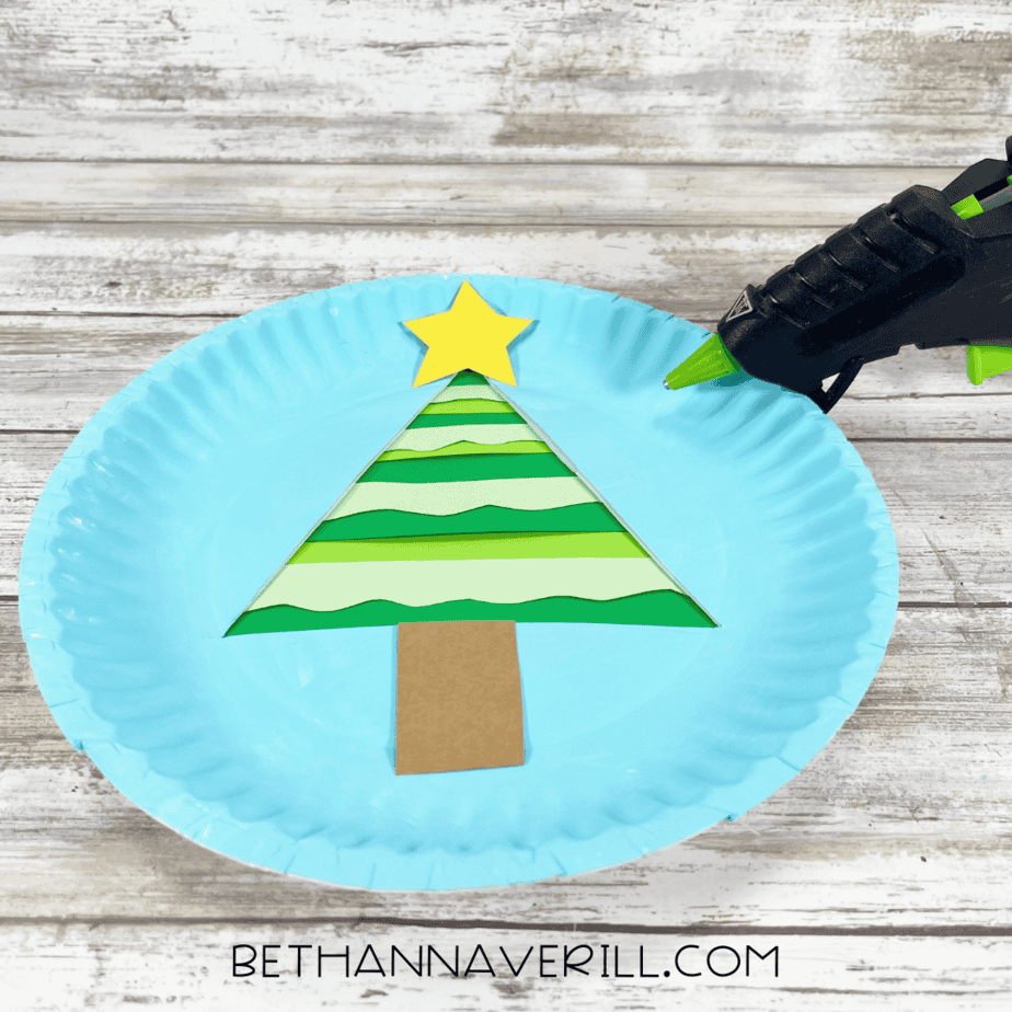 Paper plate with layered tree, star, and trunk glued together using hot glue.