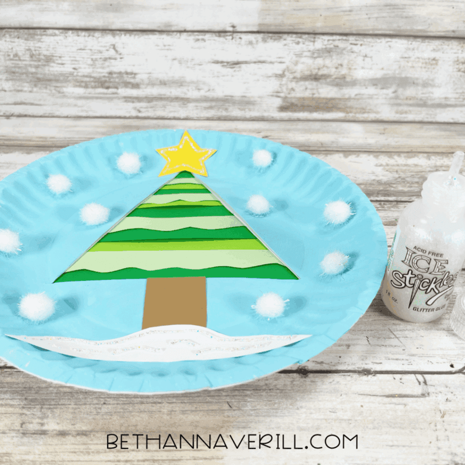 Winter tree craft with glittery star and snow accents applied with stickles.