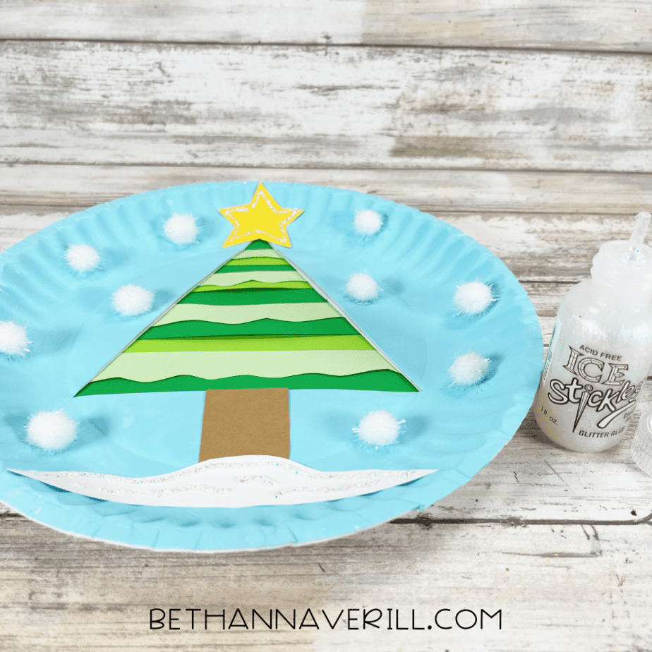 Winter tree craft with glittery star and snow accents applied with stickles.