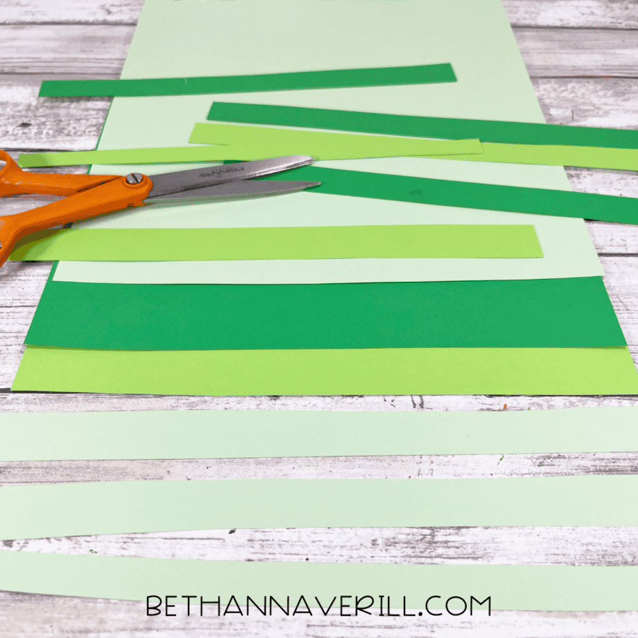 Strips of light and dark green construction paper cut and ready for the tree craft.