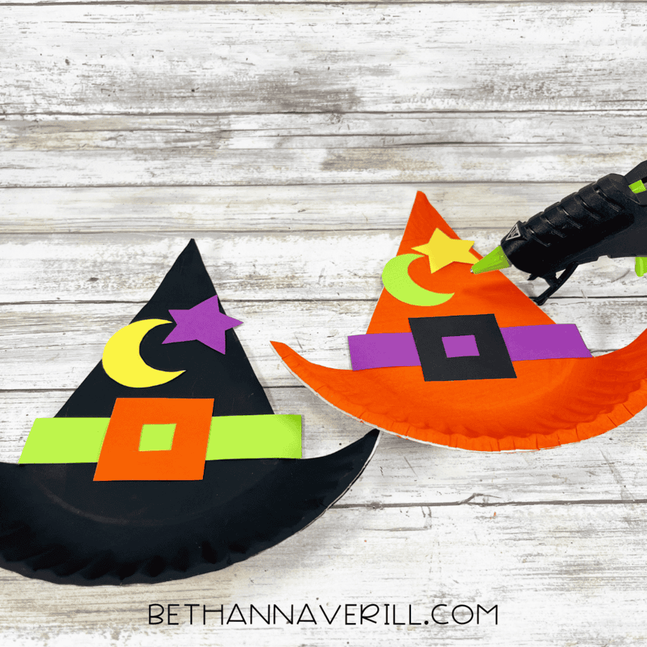 Witch hats with added moon and star decorations being glued into place.