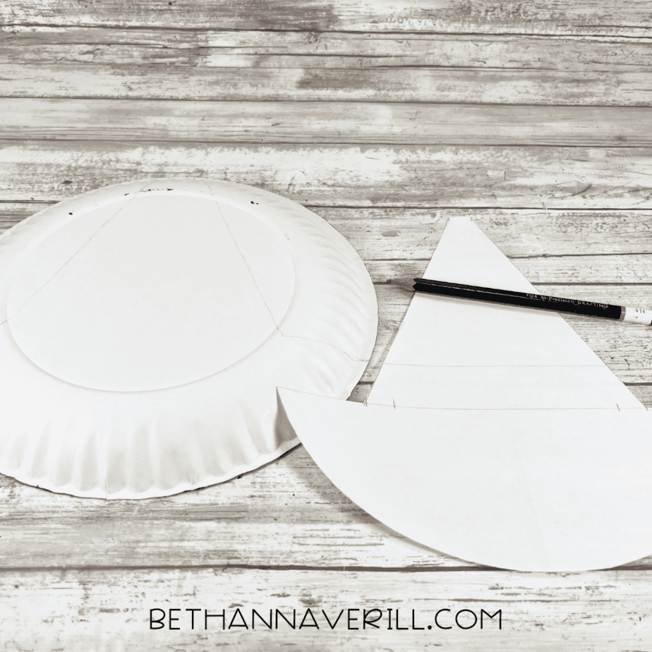 Back of paper plate with witch hat shape traced using pencil and template.